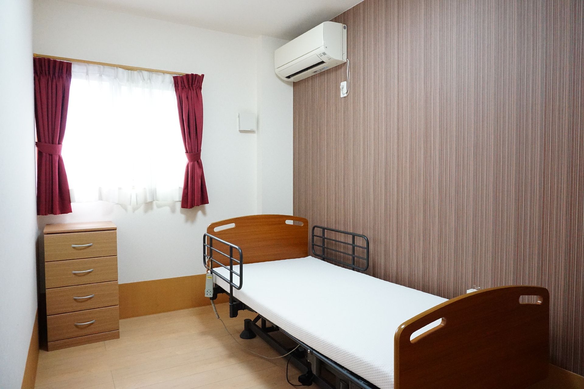 窓から日差しが入り、備え付けの介護ベッドなどがある居室