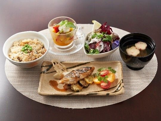 お盆にのったある日のメニューの写真。ご飯と椀物、メインの魚料理、デザートまで用意されているメニュー