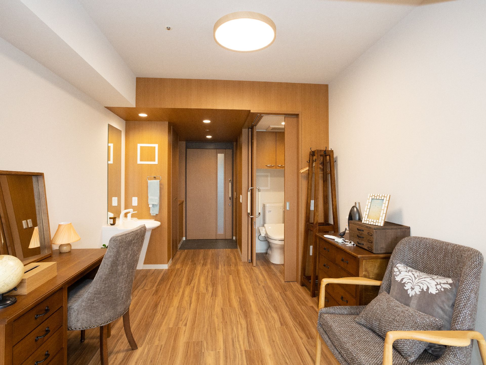 洗面台ｍトイレが設置され、机やパソコン、椅子が置かれている居室