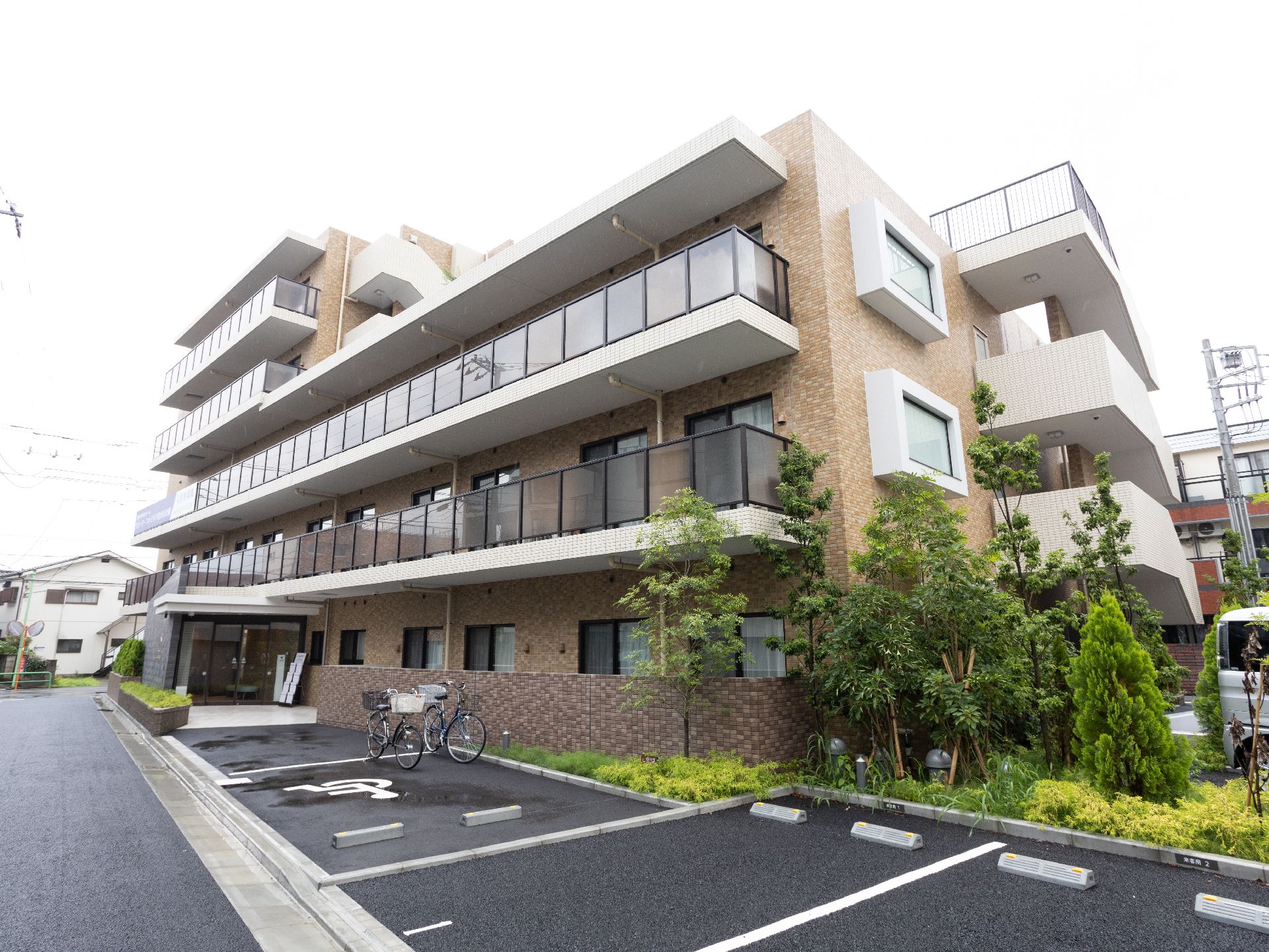 窓の枠やベランダの床部分が白色になっている印象的な施設の外観