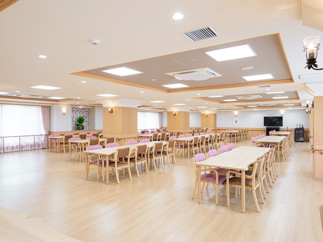 大きな窓が付いた明るい食堂にはたくさんのダイニングテーブルセットが置かれている。