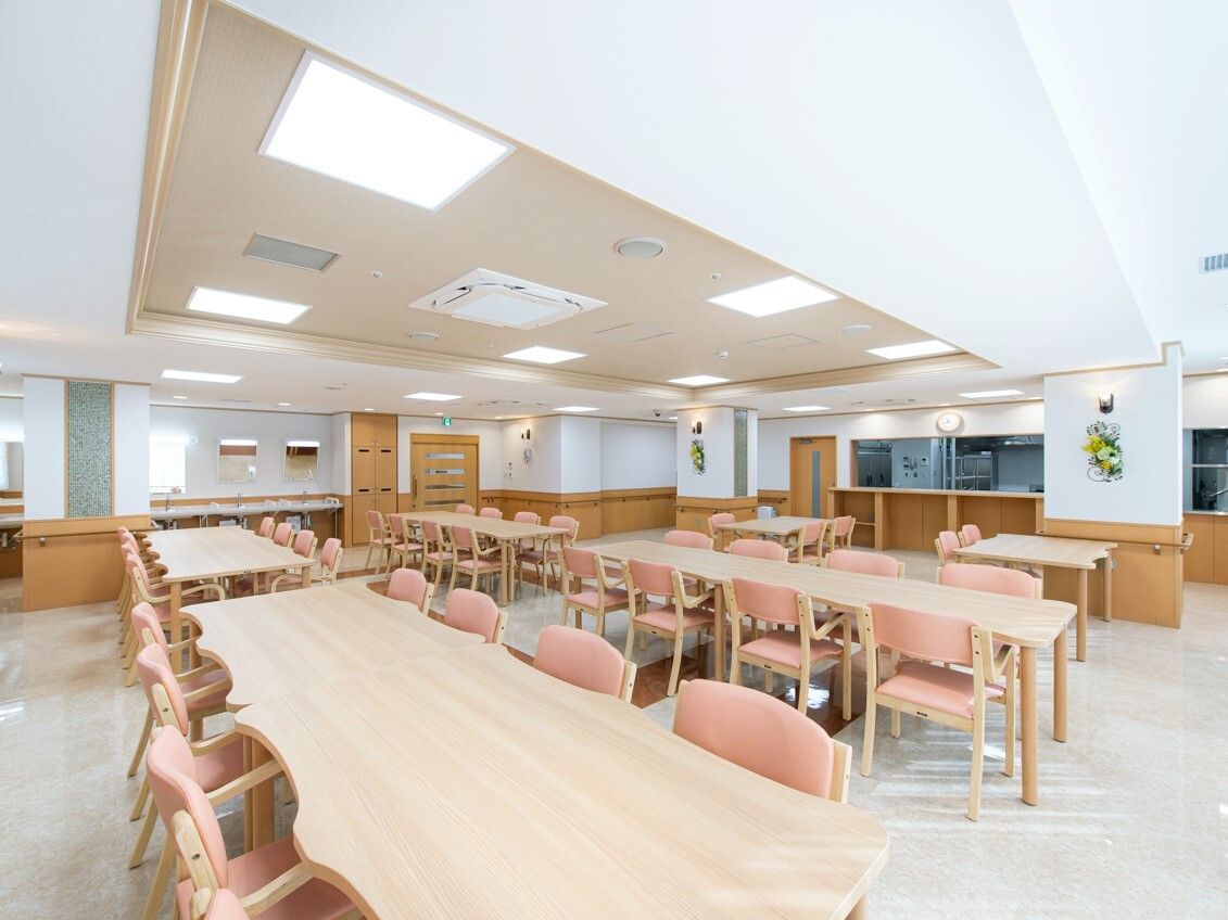 木製のダイニングテーブルセットが複数置かれた食堂のすぐそばに厨房があり、中を見ることができる。