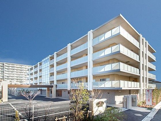 広い駐車場がある5階建ての建物は日当たりのいい場所に建っている。玄関には車寄せが付いている。