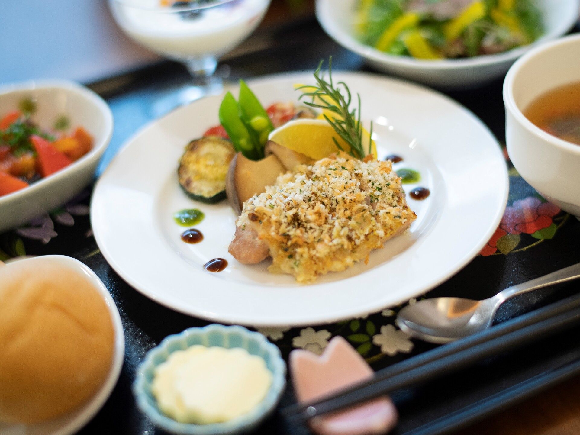 チキンの香草パン粉焼きやサラダ、パンなどが彩りよく並んだお盆