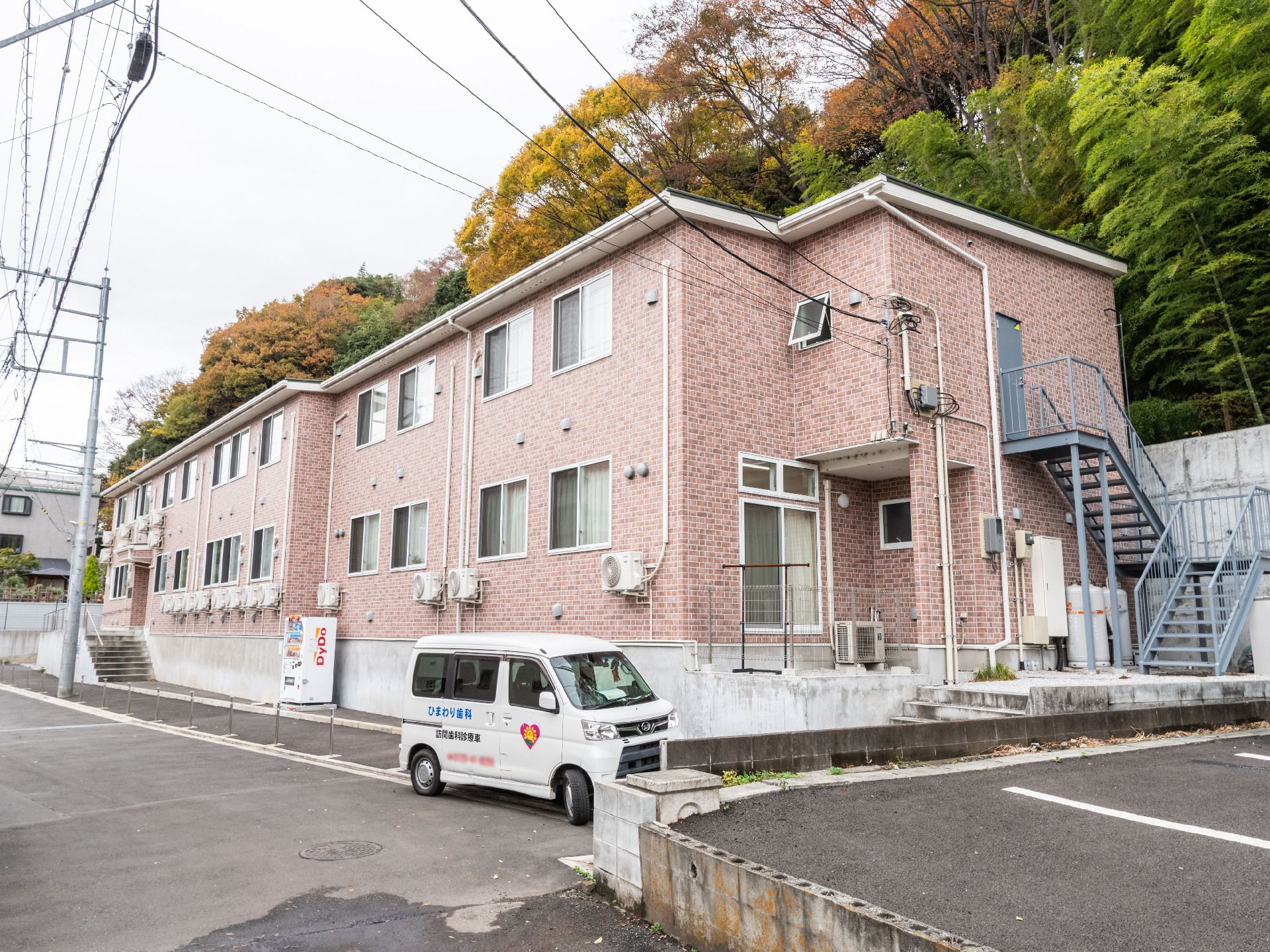 駐車場とスロープが設置してある介護施設の外観
