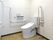 呼び出しボタンが付いたトイレは白を基調にして清潔感がある。手すりがたくさんつき、シンプルなデザイン。