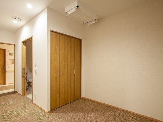 クローゼットが付いたカーペット敷きの部屋には電動物干しやトイレも設置されている。
