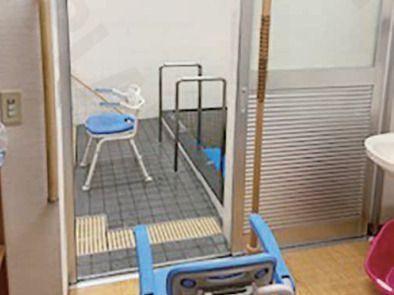 カメラに向かって笑顔を見せる車いすの女性とその家族、男女のスタッフの様子