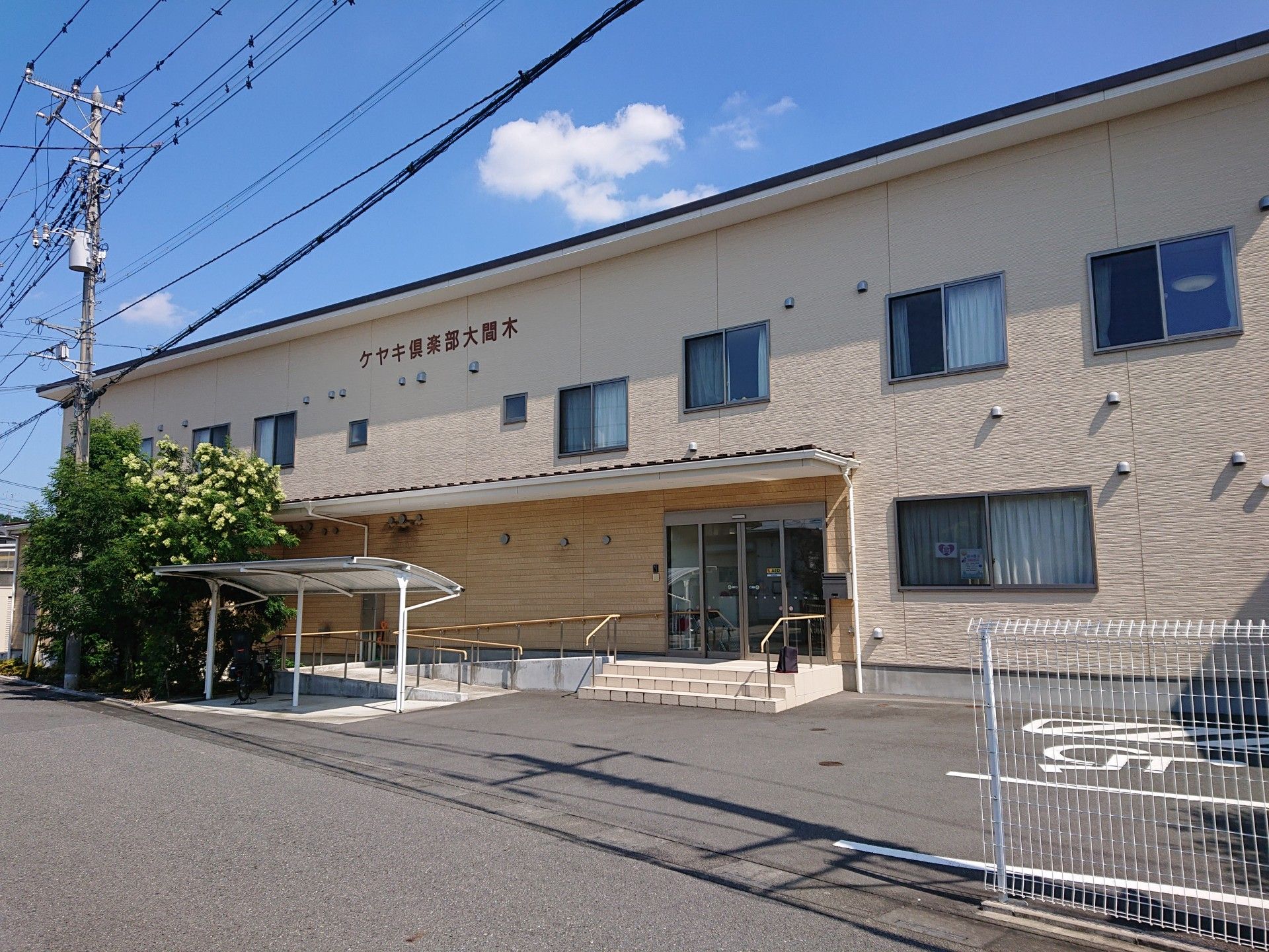 前を指差す高齢女性と後ろで見守る女性ヘルパー