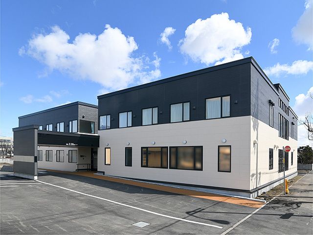 駐車場も完備されている広い敷地内にはモノトーンの2階建ての建物が建っていて、周りに背の高いものはない。