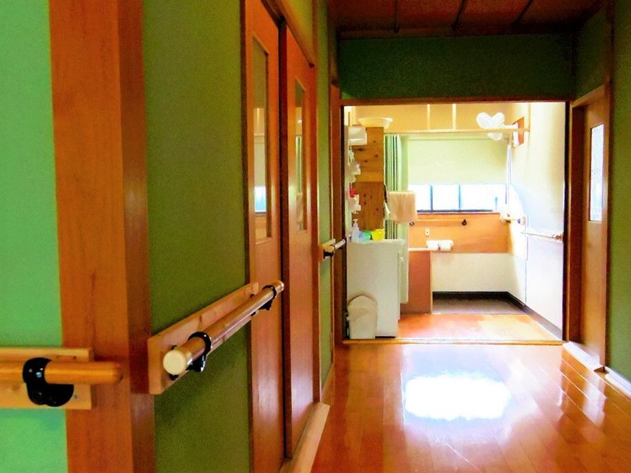 手すりが続いている廊下、奥に共有スペースが広がる