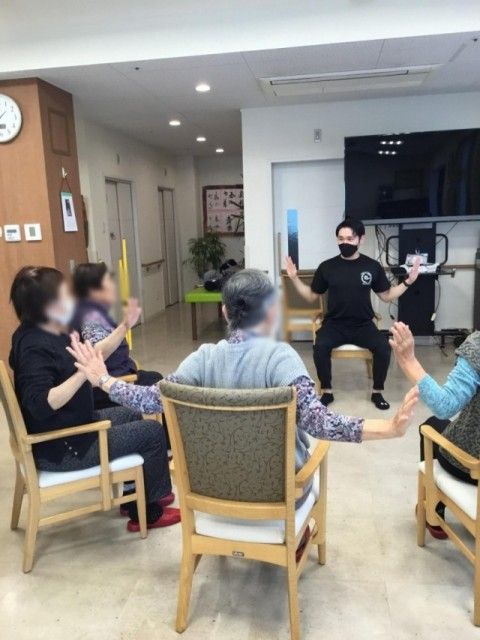 椅子に座って体操する人々