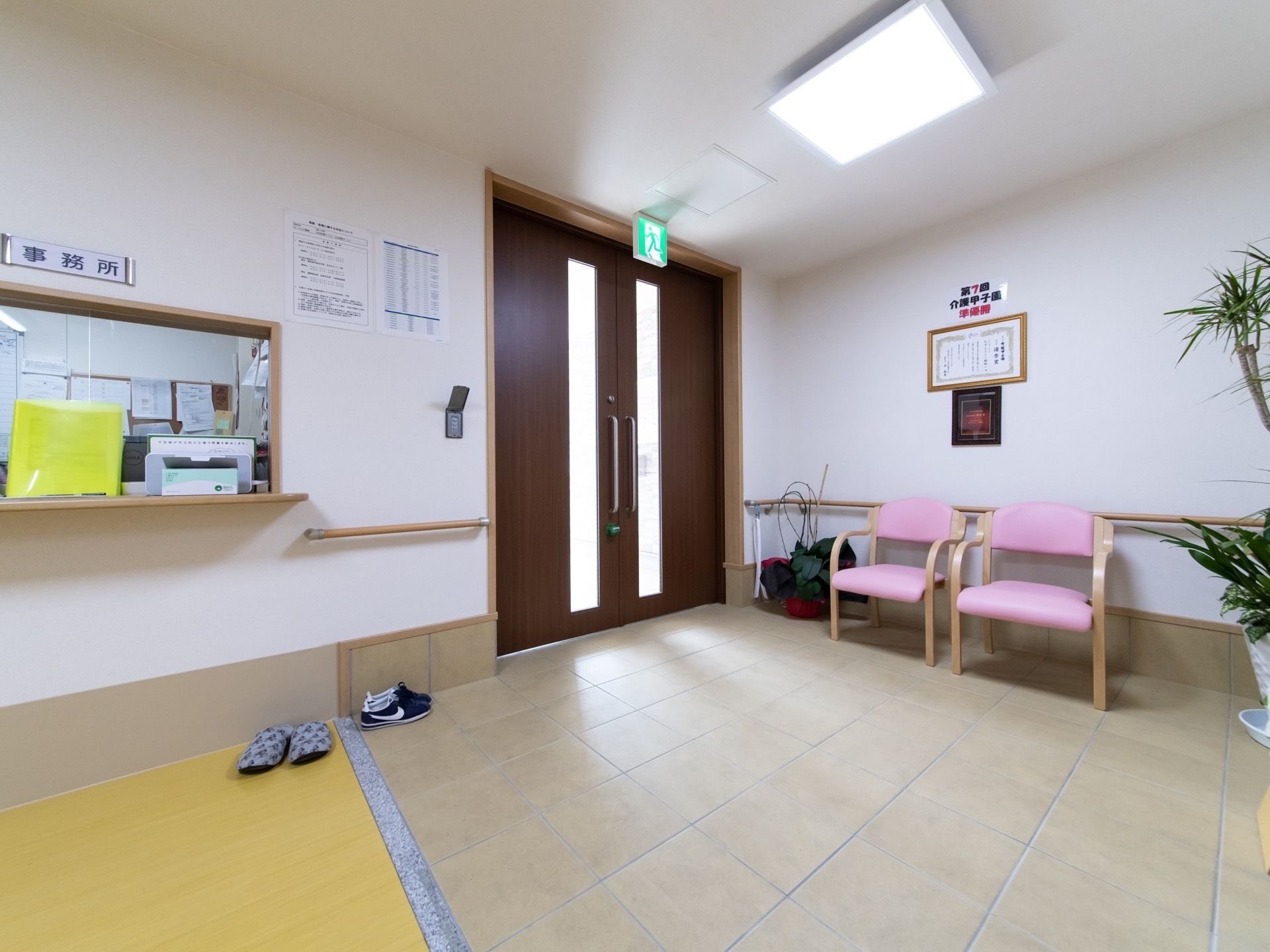 施設内のエントランス付近を写した写真。腰掛用のいすやスタッフステーションが映っている様子