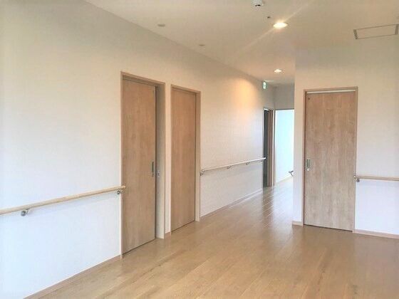白い壁に木目調の建具が設置された館内はナチュラルな雰囲気。木目調の手すりも設置され、廊下の幅もゆとりがある。