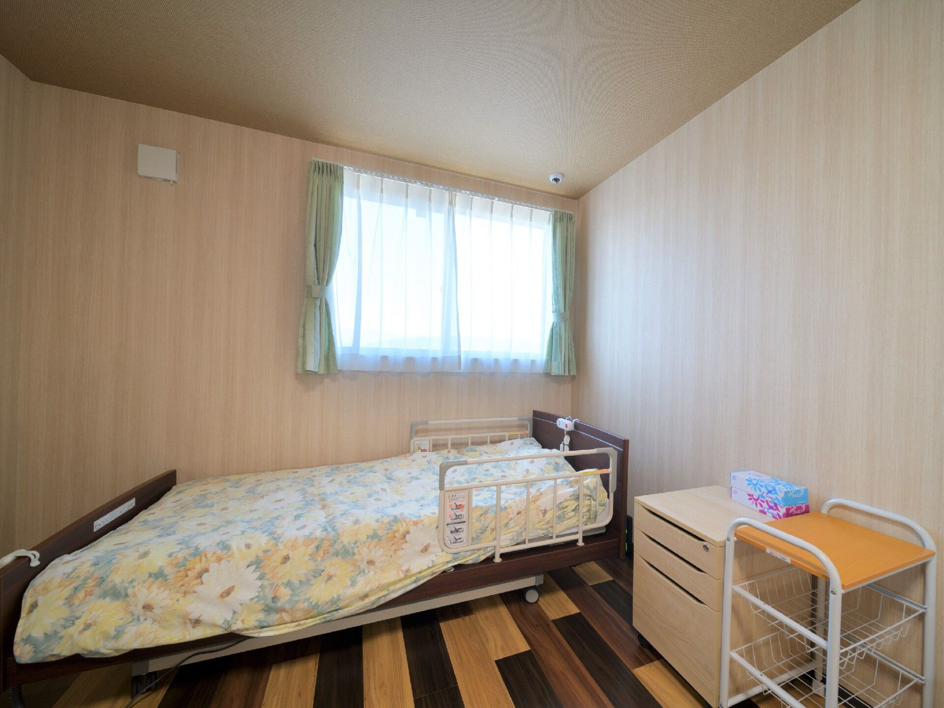 居室には窓が設置され、外からの光が射し込んでいる、ベッドや収納が備えついている