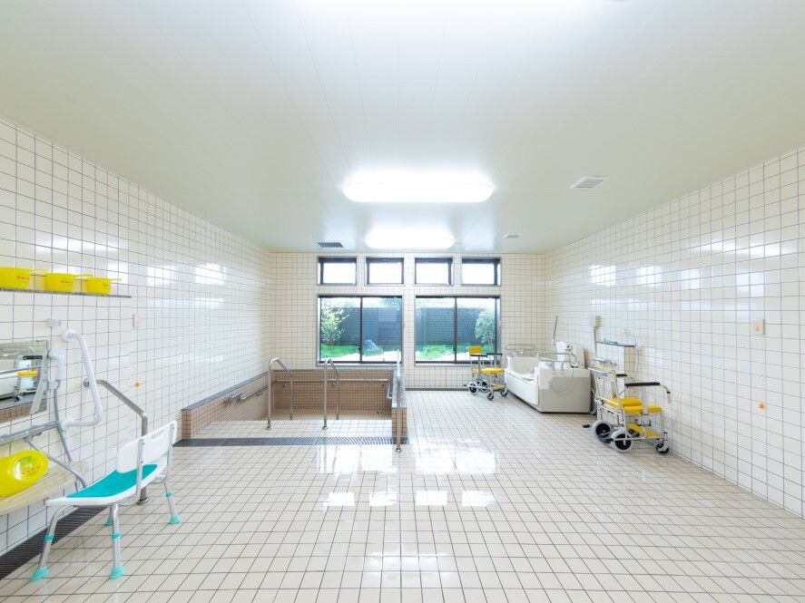 機械浴やシャワー、床面が坂となっている大浴槽などがあり、窓も大きい。壁には緊急通報装置が付いている。