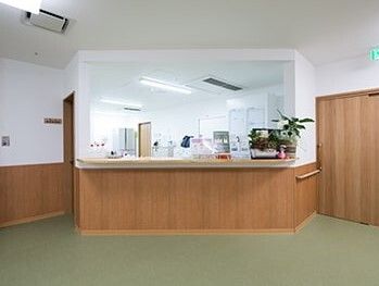 開放的なサービスステーション。ステーション内にはデスクや棚が並び、カウンターには観葉植物が飾られている。