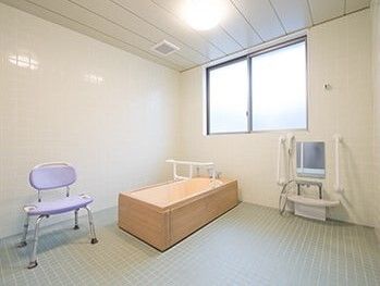 木製の浴槽が設置された広い浴室にはシャワーチェアとシャワースペースもある。