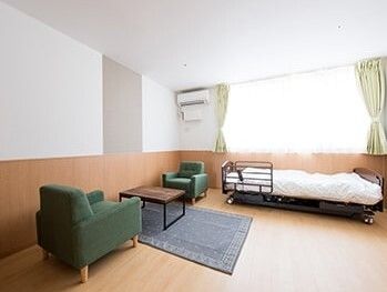 大きな窓があり明るい雰囲気。居室には、ベッドや応接セットだけでなくエアコンもついている。
