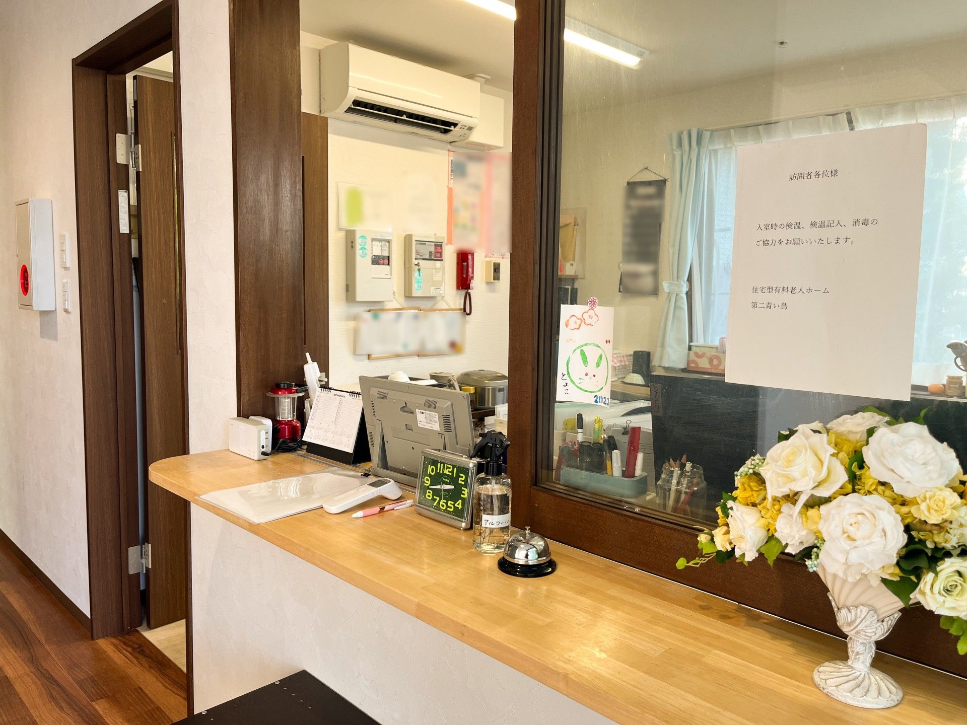 白いお花があり、横には呼び出し用ベルと体温計が置いてある