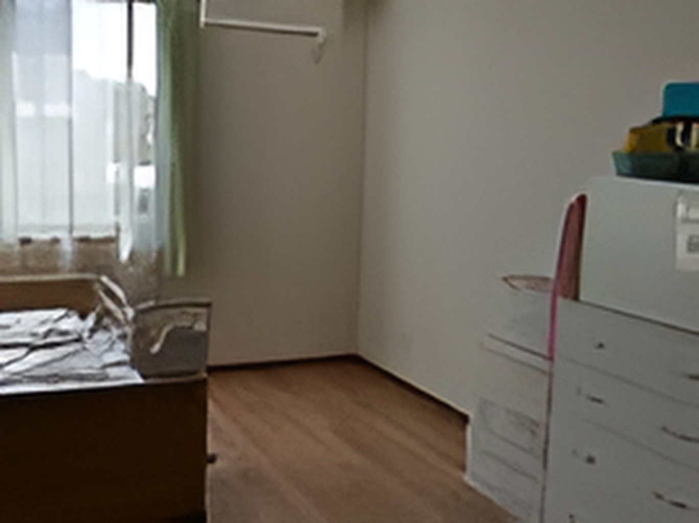 フローリングの部屋にはタンスや介護ベッドが置かれ、大きな窓にはカーテンが付いている。