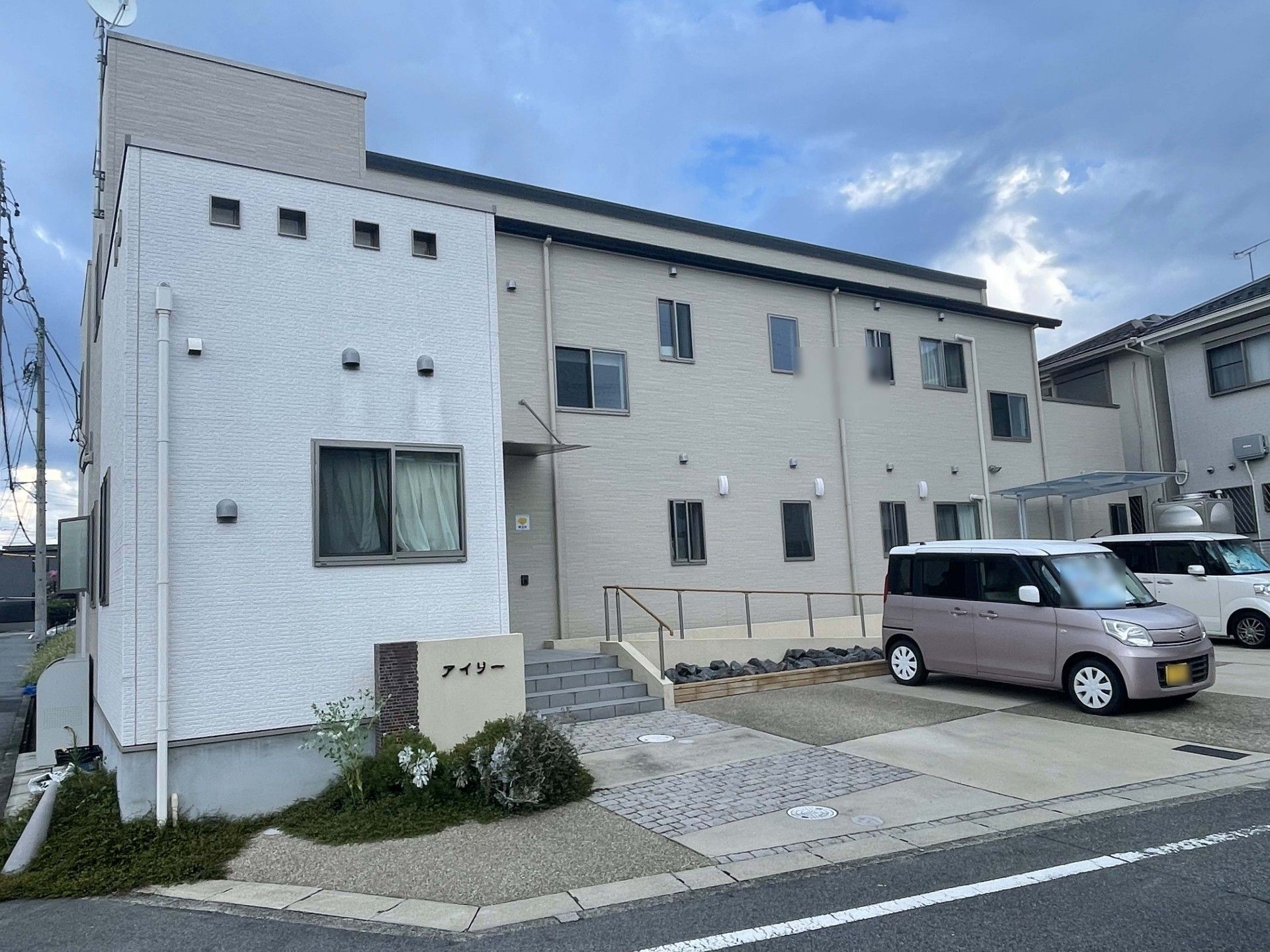 駐車場とスロープのある外観