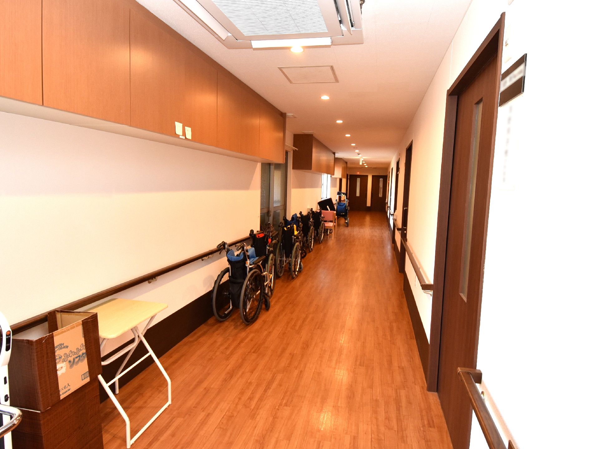 呼び出しボタンや手すりが設置された壁。トイレの便座にも手すりや背もたれがあり、手洗い場も付いている。