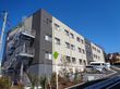 外階段があり、ツートンカラーの外壁の3階建て建築物