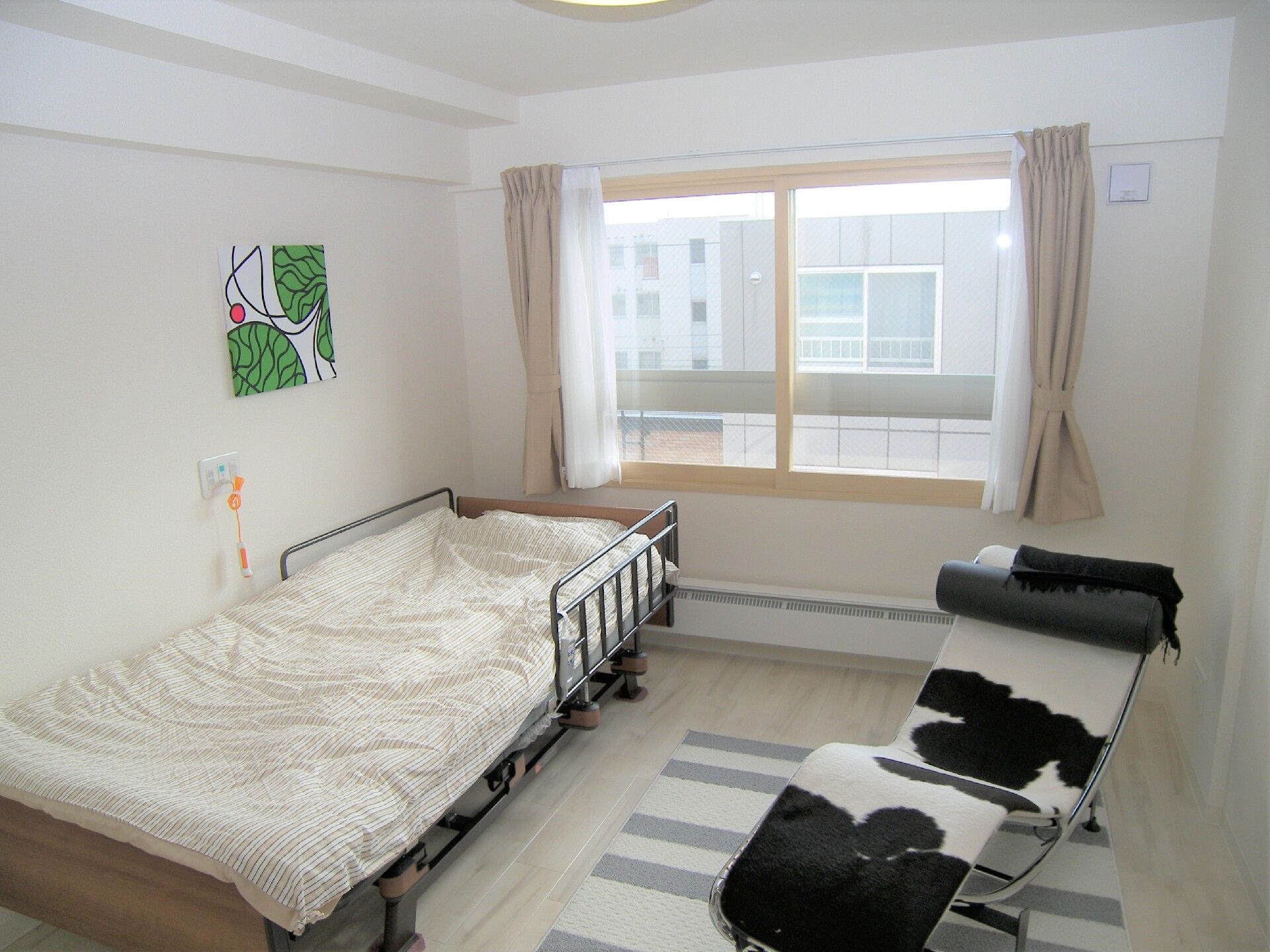 大きな窓が付いた個室のお部屋。介護ベッドや椅子が設置されている