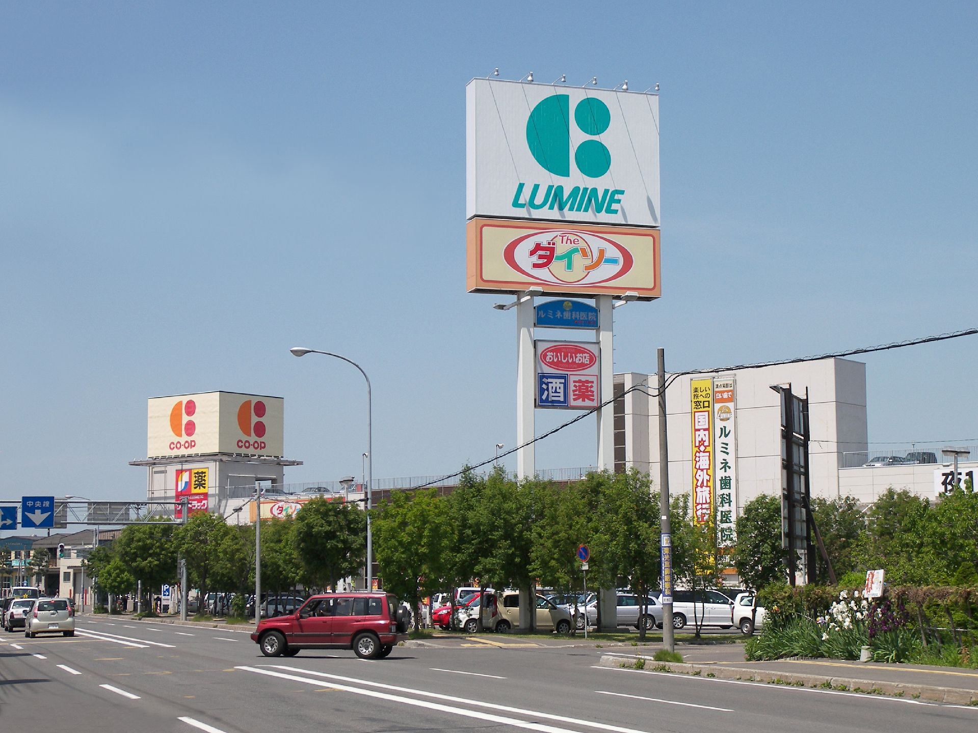 ダイソーなど複数のy操業施設が写っている施設周辺の写真。大きな道路がある様子