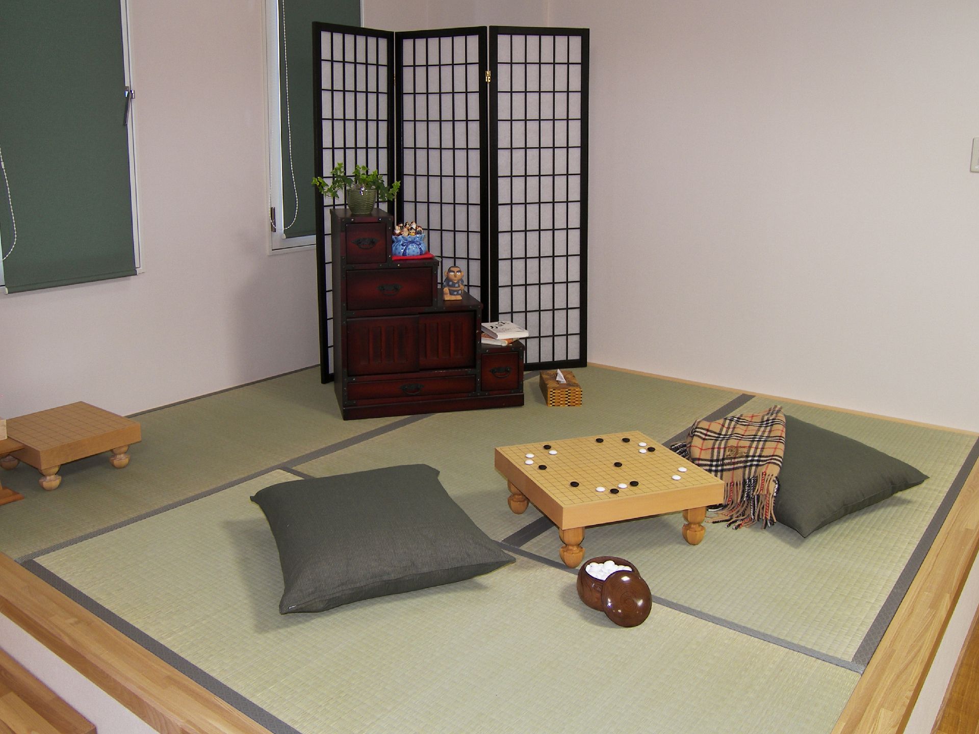 畳が敷かれている小上がりの様子。将棋台と座布団、階段ダンスが置かれている