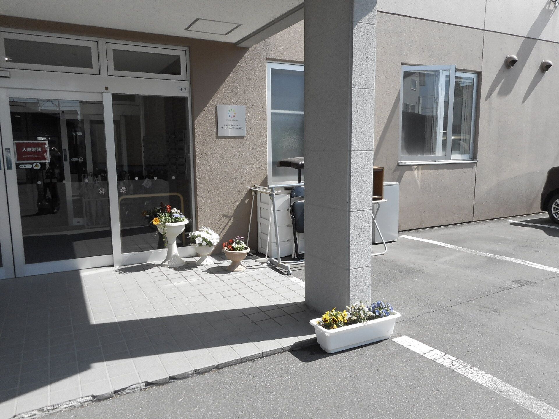 施設のエントランス付近。右側に駐車場、左側に入り口が写っている様子