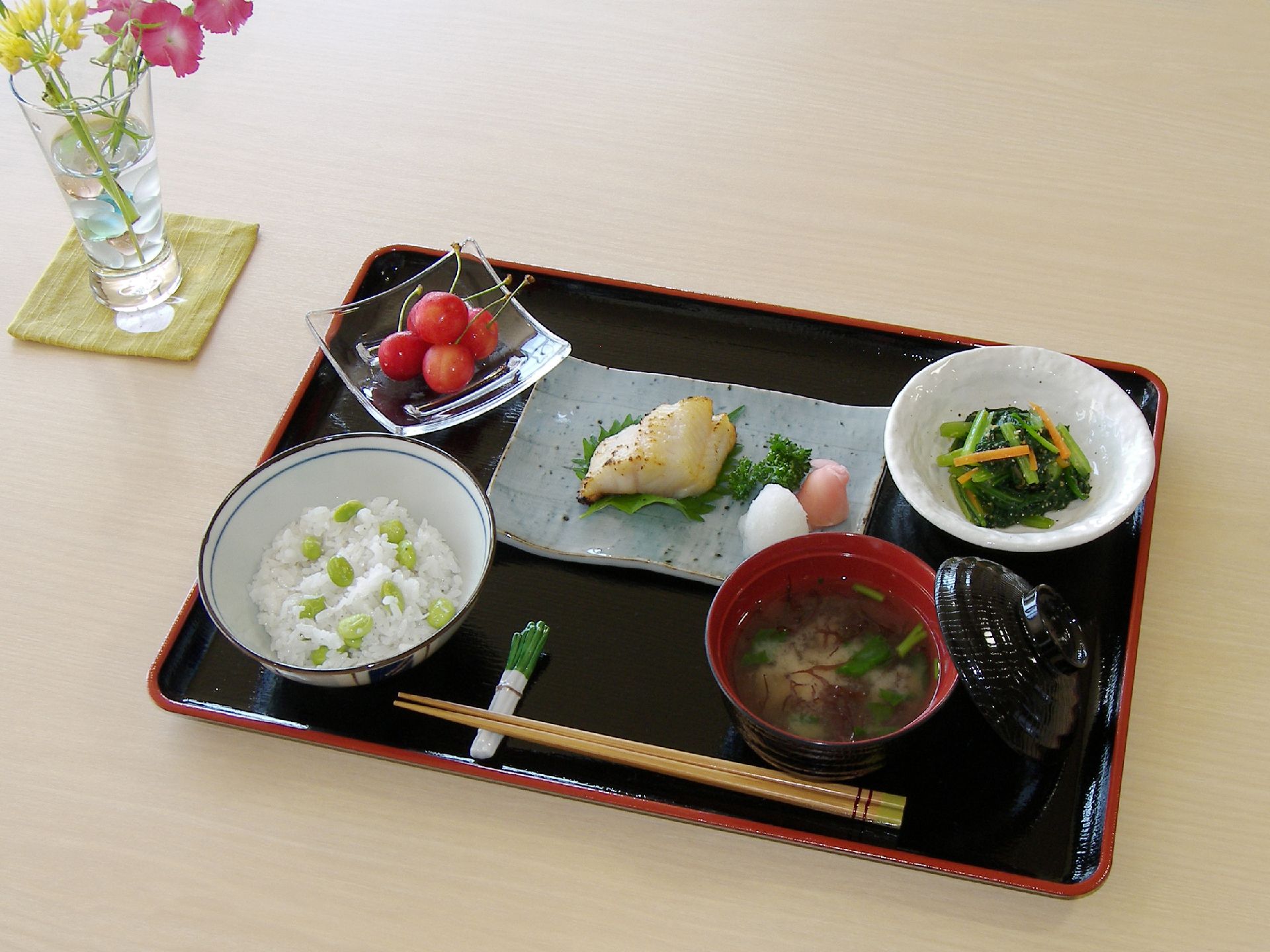 豆ごはんと魚のおかず、副菜、ご飯、みそ汁が用意されているメニュー例
