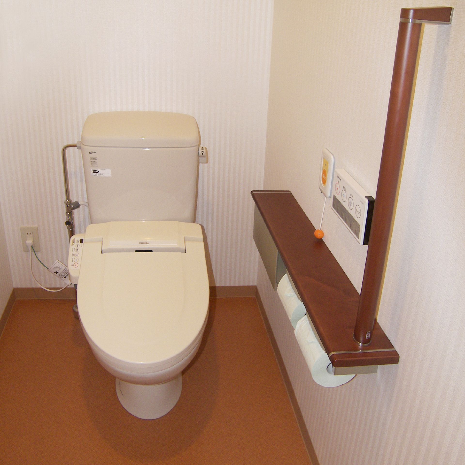 手すりと緊急コールがついた施設内のトイレの様子。小さめのスペース