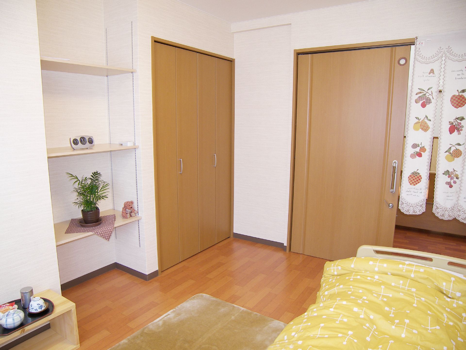 入口に暖簾のかけられた、作り付けのクローゼットや棚がある部屋