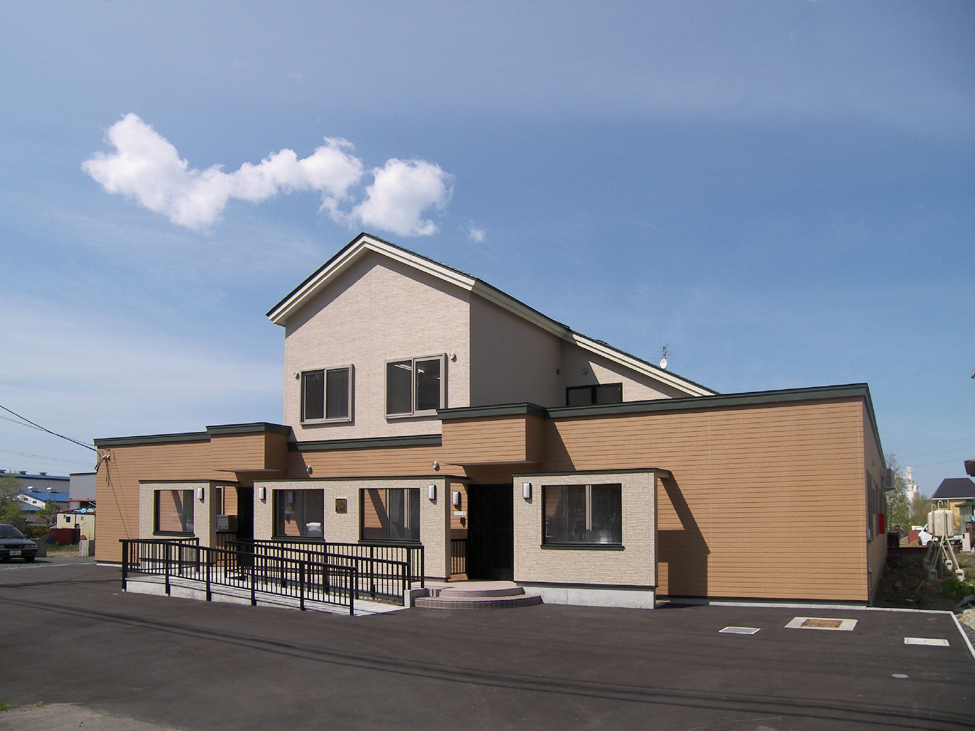 建物前に広々としたスペースが広がり、入り口に緩いスロープが設置された施設