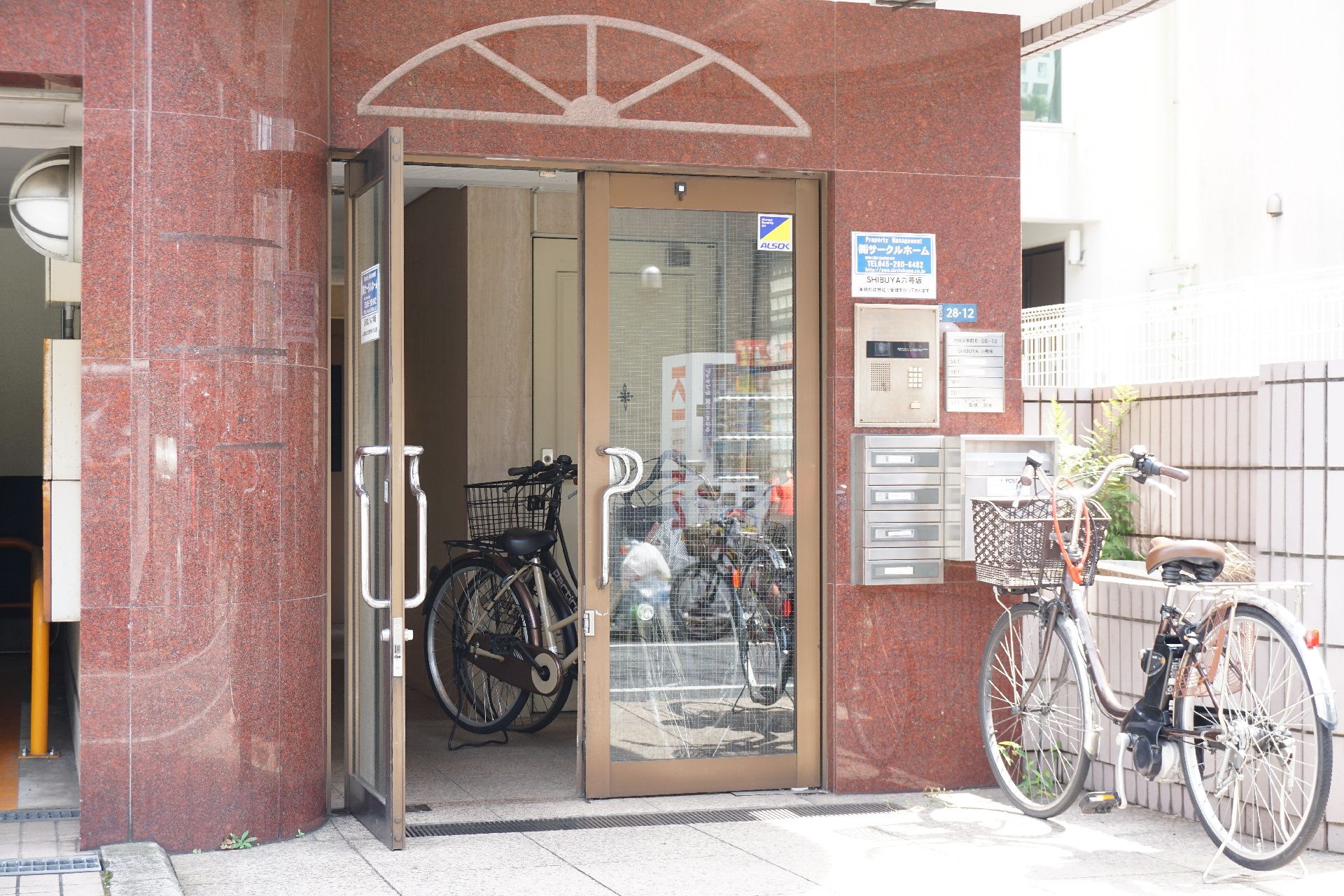 高級感のある壁で、自転車が置かれている施設のエントランス