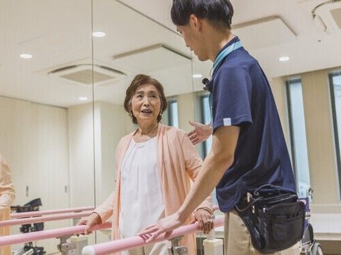 各フロアにベランダがあり、建物周辺には草木が植えられた住宅。ダークグレーの3階建てでスタイリッシュなデザイン。