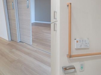 右側にはトイレのエル字型の手すりと緑の呼び出しボタンがあり、左側には居室の出入り口の段差が解消された画像が映っている。