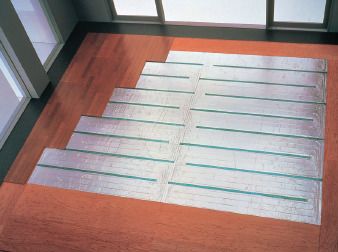 グリーンのラインが入ったシルバーのシートが敷かれたフローリングの床。上部と左側には窓が設置されている。