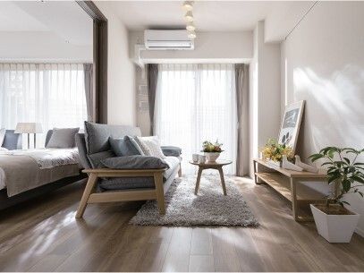 日当たりのいいフローリングの部屋にはソファやベッドがあり、棚の上には絵画や花が飾られ、ソファの前のテーブルの上にはティーセットが置かれている。