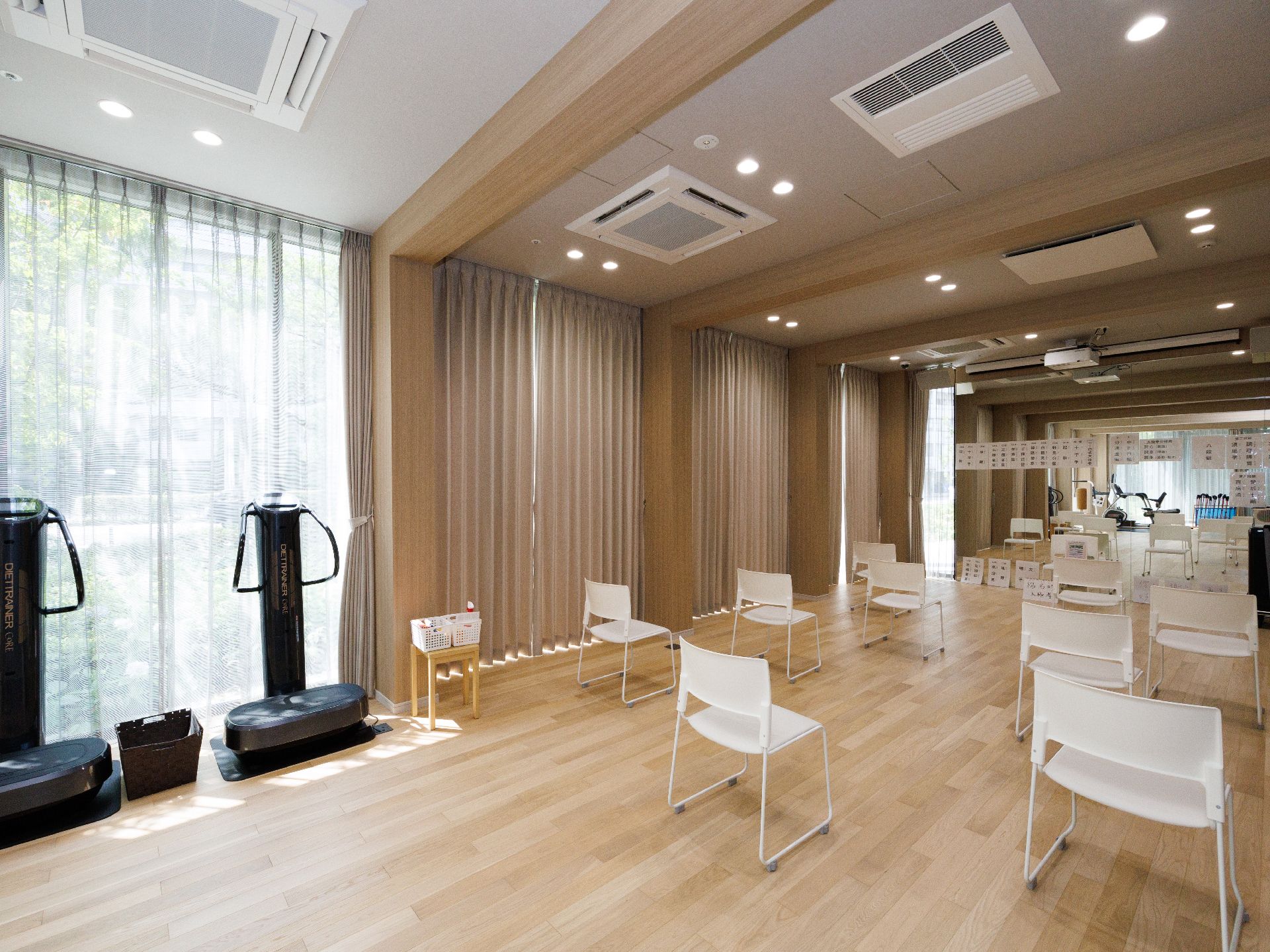 壁一面に大きな窓が並んだ部屋にある感覚が空いて並んだ白い椅子