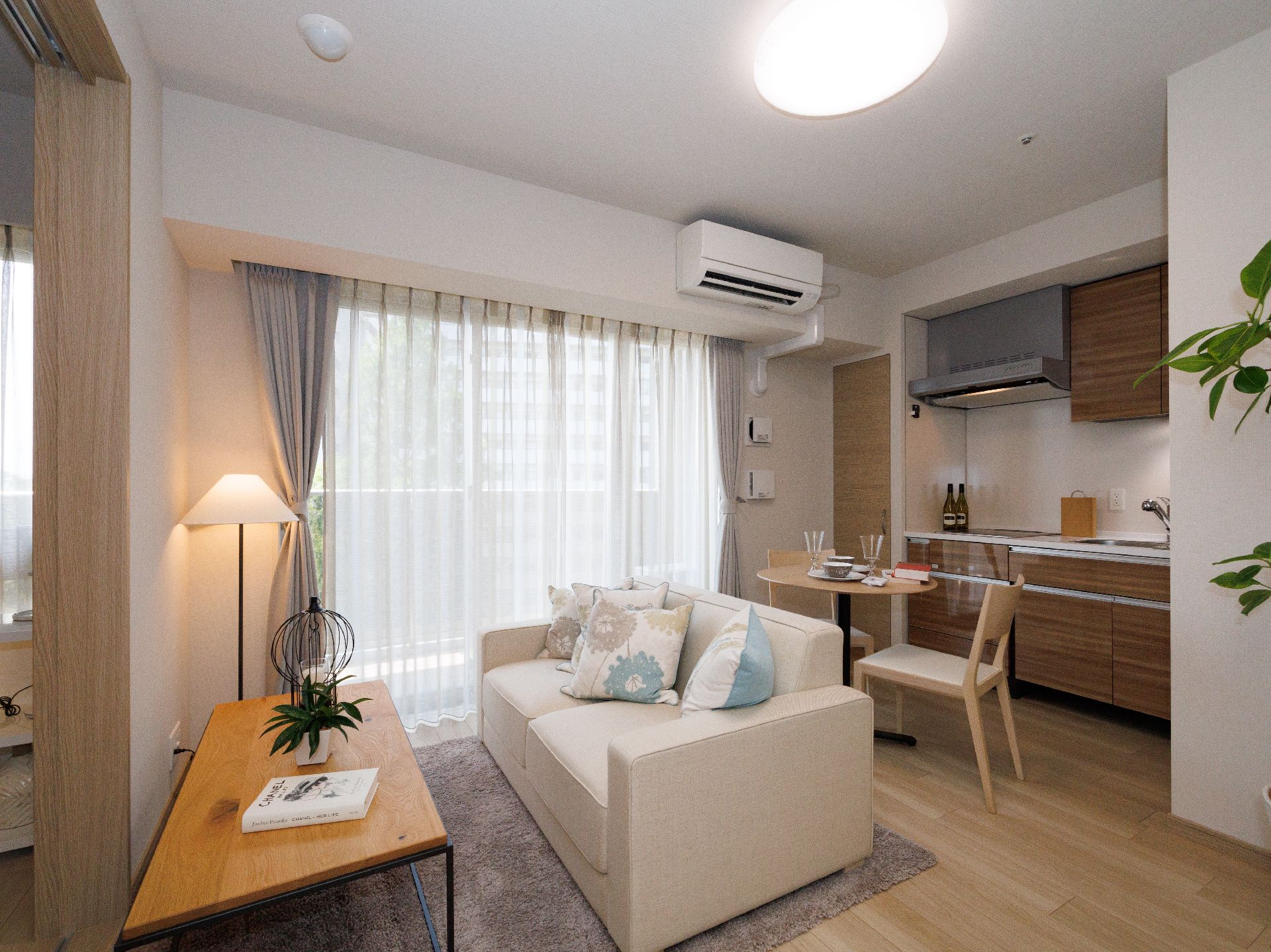 キッチンのついた部屋に置かれた２人掛けのソファーと机