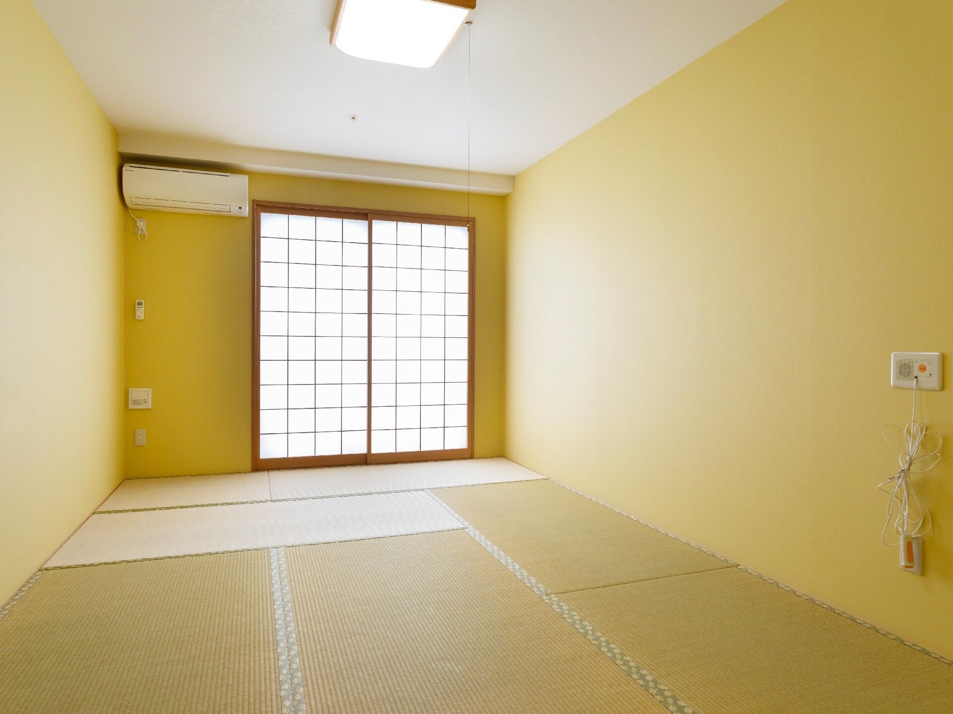 ブルーのエプロンを付けた若い女性スタッフがジャケットを着た高齢女性に付き添い、散歩をしている。
