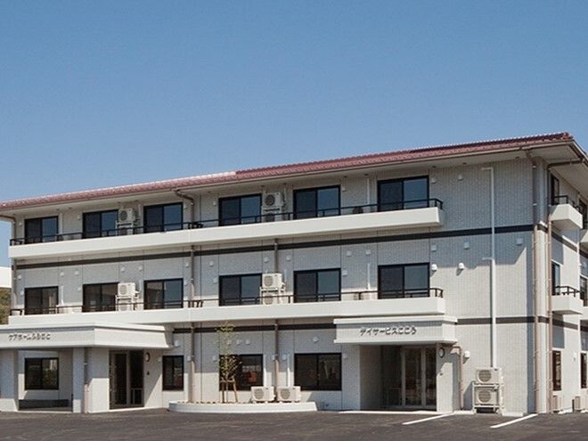 各フロアにベランダもある3階建ての建物の前には駐車場があり、出入り口が2カ所に設置されている。
