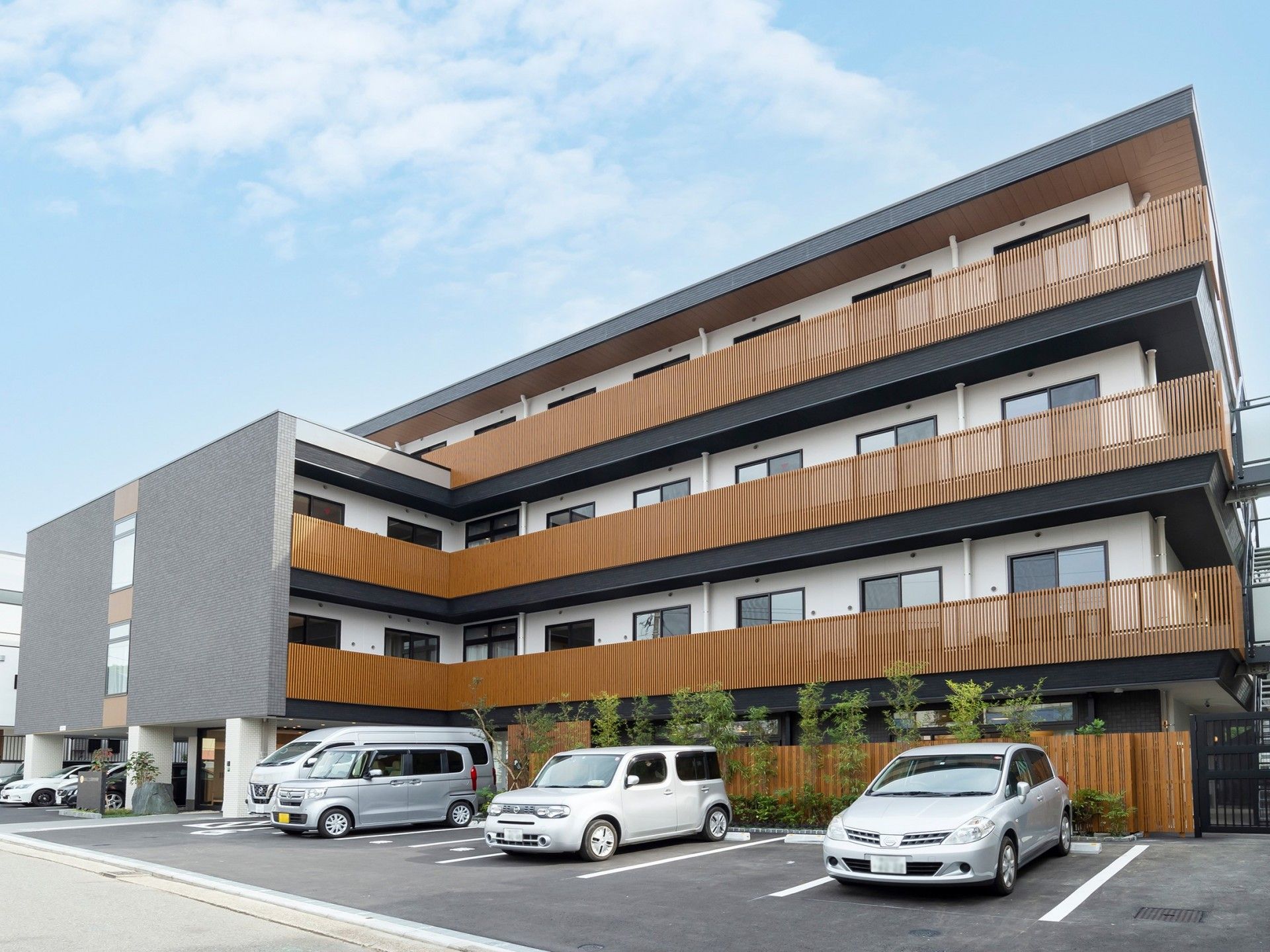 部屋の周囲に茶色い柵がある、4階建ての老人ホーム