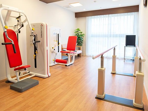 リハビリ用の機械や平行棒が設置されている部屋