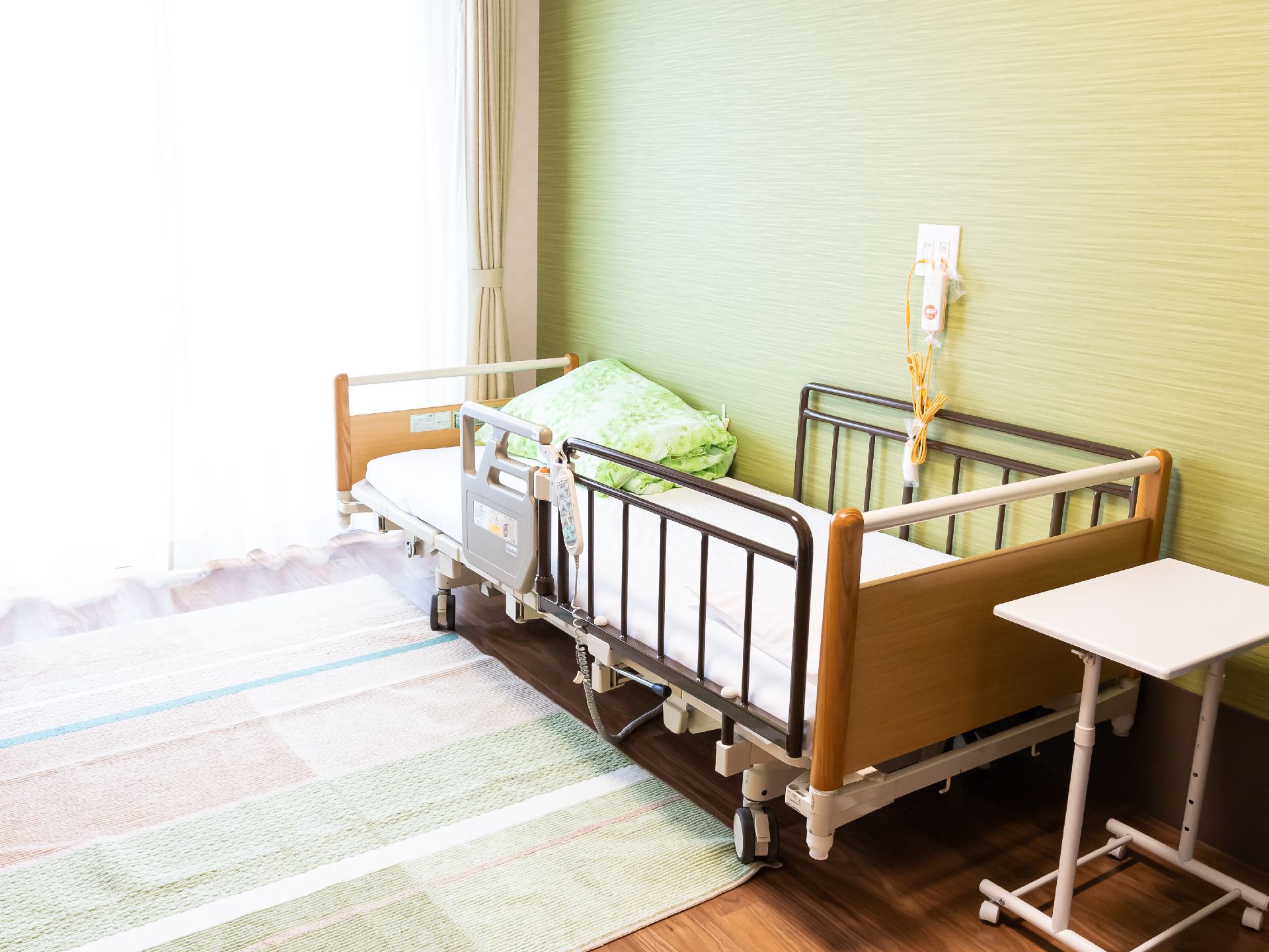 窓から陽光が差し込み、介護ベッドが置かれている居室