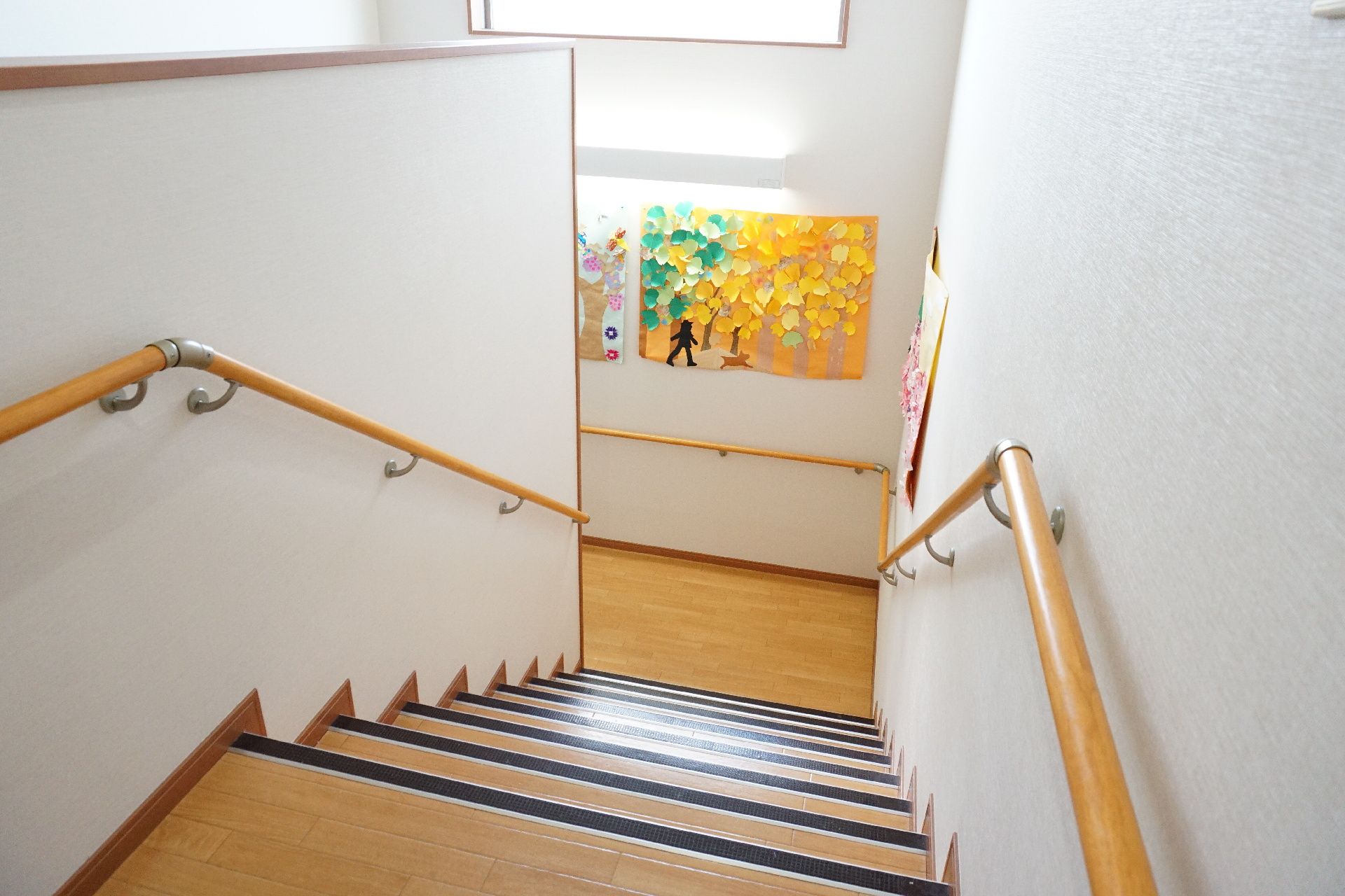 各段に滑り止めが設置され、壁に手すりが取り付けられている階段
