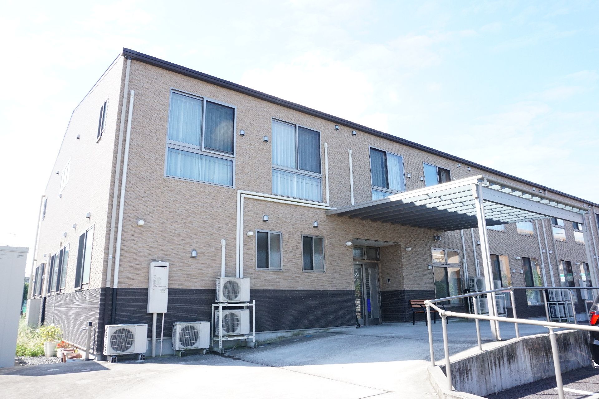 2階建てで、茶色の落ち着いた色合いが特徴の施設の外観